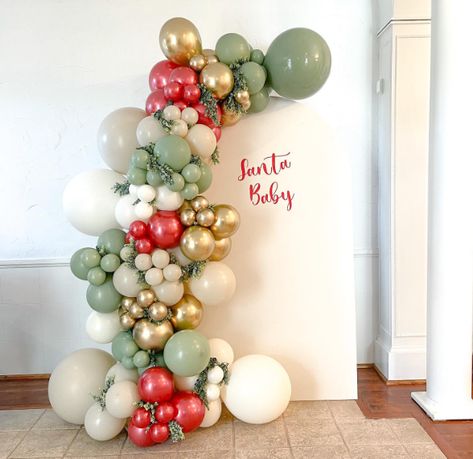 15 Best December Baby Shower Ideas - www.mummytries.com Christmas Gender Reveal Balloon Arch, Red And Green Gender Reveal Ideas, Christmas Baby Shower Balloon Arch, Christmas Party Balloon Arch, Christmas Gender Reveal Decorations, Xmas Baby Shower Theme, Christmas Arch Decor, Santa Baby Gender Reveal Ideas, Christmas Baby Shower Backdrop