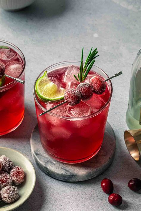 Made with cranberry juice, maple syrup and a splash of ginger beer, this Christmas gin cocktail is crisp and refreshing. We've garnished it with fresh rosemary and sugared cranberries for a festive, vibrant cocktail that will be the hit of your holiday gathering. Cranberry Ginger Beer Cocktail, Cocktail With Rosemary, Christmas Cocktail Garnish Ideas, Christmas Cocktail Garnish, Christmas Rum Drinks, Festive Cocktails Christmas, Gin Christmas Cocktail, Christmas Gin Cocktails, Cranberry Christmas Cocktail