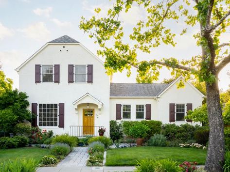 "This was a wealthy town in Victorian times; a lot of houses, like ours, were built around that period," say homeowners Susan and Bill Arbios. Many homes’ shutters are just for show, but these are fully functional. They’re made of colored resin. In the ’30s, the stucco and the Dutch-inspired roof were added to make the exterior look less old-fashioned. "We love how unique it is!" The homeowners planted wedding bells, a type of rose, along the walkway for their 20th anniversary a few years ago. Other roses in the yard include Ebb Tide (known for their smoky purple color and strong fragrance of cloves) and New Year (which don’t have thorns, so they’re great for picking and arranging). "We usually have four or five bouquets of flowers from our own garden in the house," they say. Location: Hea Brown Shutters, Fixer Upper Inspired, Italian Cypress, Hardscape Design, Hgtv Magazine, Magazine Pictures, Porch And Balcony, Farmhouse Holiday, Above Ground Pool