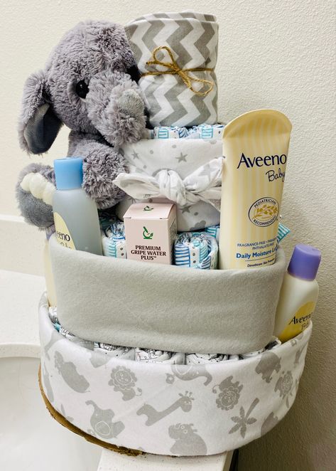 Baby boy diaper cake made from diapers, a paper towel roll, receiving blankets, baby toiletries, and a stuffed elephant 💙 Baby Boy Diaper Cake, Stuffed Elephant, Baby Essentials Newborn, Baby Toiletries, Diaper Cake Boy, Blankets Baby, Baby Shower Diaper Cake, Baby Equipment