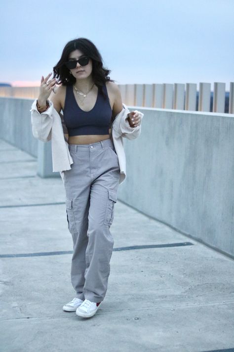 Summer/ spring street style inspiration. grey cargo pants, garage dark purple tank top and beige cartigan. gold jewelry with big black acrylic sunglasses from shein. red nike blazer mids. photoshoot location at a parking garage at toronto premium outlets Dark Grey Cargo Pants Outfit, Grey Cargo Pants Outfit, Lace Tank Tops Outfit, Blazer Mids, How To Style Nike Blazers, Acrylic Sunglasses, Red Cargo Pants, Parking Garage Photoshoot, Garage Photoshoot