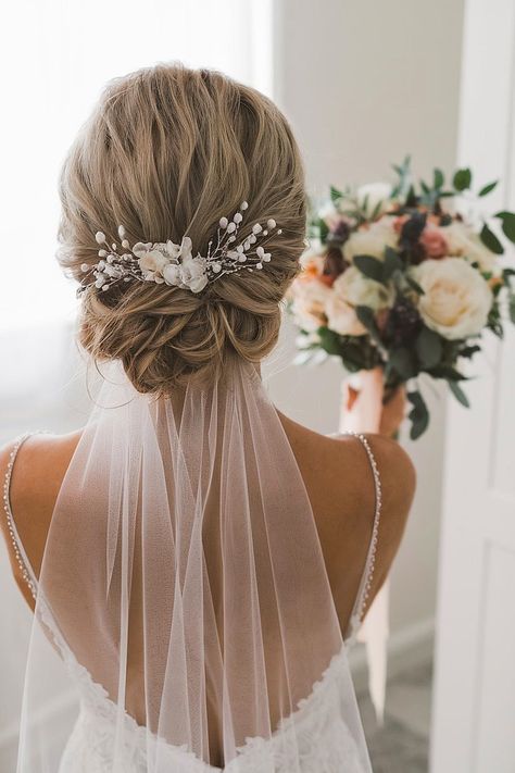 Bridal updo with veil and floral accents for wedding day. Braided Bridal Updo With Veil, Low Wedding Updo With Veil, Updo Hair With Veil, Bridal Hair Bun With Veil, Wedding Hair For Bride With Veil, Updos With Veil, Wedding Hairstyles With Veil Updo, Wedding Hairstyles Updo With Veil, Bun With Veil