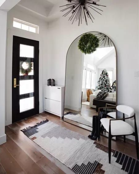 Transitional entryway in our home with our runner on sale for $40 off! We have the size 2.5’ X 7’! Love this massive floor mirror to add a grand sense of scale to our entry. The glass floats in the brass frame for a very sleek look. Added a dining chair with arms for people to sit down and take their shoes off, too! #LTKstyletip #LTKsalealert #LTKhome Entry Way Leaning Mirror, Big Mirror Entryway, Arched Mirror Entryway, Arch Mirror Entryway, Large Mirror Entryway, Transitional Entryway Decor, Foyer Rugs Entryway, Floor Mirror Living Room, Mirror Chair