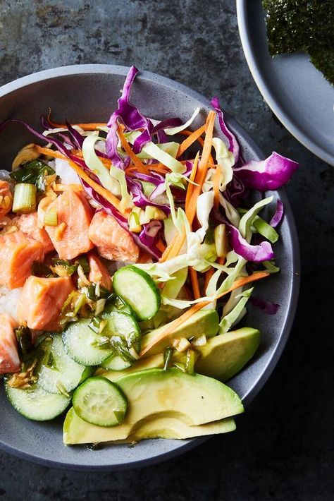 A tangy-sweet sushi-style rice with cubed salmon steamed on top. Serve with packaged coleslaw mix, sliced cucumbers, & avocado. Drizzle with vinaigrette of soy sauce, white vinegar, safflower oil, green onions, ginger & sesame oil. Can garnish with strips of nori or sprinkle with furikake. #Asian-style Sesame Salmon, Ny Times Recipes, Salmon Bowls, Nyt Recipes, Leafy Salad, Roasted Chicken Thighs, Salmon Bowl, Salmon And Rice, Nyt Cooking