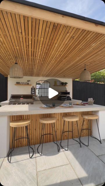 Esme | Garden Design & Landscaping on Instagram: "ALL WEATHER OUTDOOR KITCHEN 👨🏻‍🍳🍔🍕Our classic concrete x render kitchen but this time, it’s rain-ready!🌧️ Which means, outdoor BBQ’s & entertaining all year round (sub degree temperatures excluded)

We fitted out this incredible galley way kitchen for the Brookfield family with:
→ Two concrete counters; worktop & breakfast bar
→ @beefeaterbbq 7000 series 5 burner
→ @gozney pizza oven
→ @keburgarden larch wood pergola & cupboards
→ Ample storage space 
→ Integrated Bull fridge 
→ @sgweberuk chalk render walls

Drop us a message so we can build you your dream outdoor kitchen & entertainment space ✉️

#outdoorkitchen #outdoorliving #outdoorkitchendesign #gardendesign #landscaping" Bbq Bar Outdoor, Outdoor Kitchen Design Wood, Bbq Area Ideas Outdoor, Gozney Pizza Oven, Deck Kitchen, Concrete Counters, Concrete Outdoor Kitchen, Bbq Bar, Outdoor Bbq Area