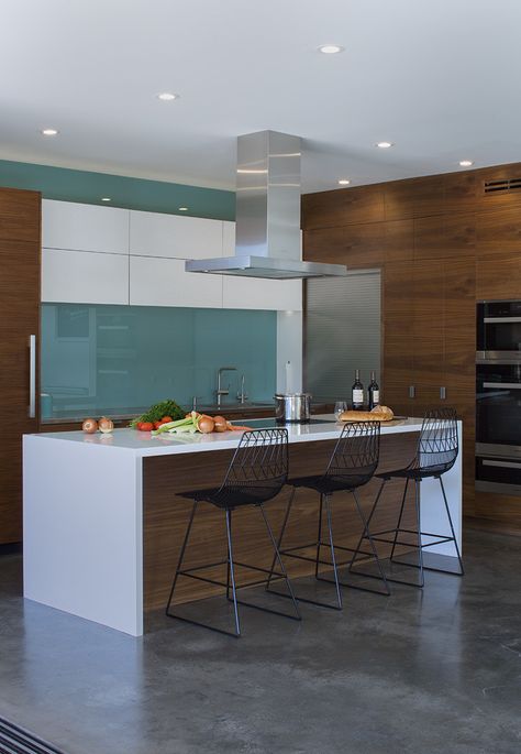 In the kitchen, a blue glass backsplash evokes the designers’ native Iceland. The <br>Bend Goods stools are from YLiving. Kitchen Iceland, Blue Glass Backsplash, Range Hood Wood, Walnut House, Rustic Backsplash, Modern Backsplash, Backsplash Wallpaper, Colorful Backsplash, Stainless Steel Backsplash