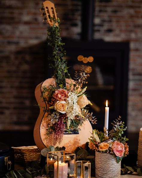 Guitar Bouquet This handmade art piece is made of an old guitar, found in an attic and stuffed away to never be used again. It was given a second life as beautiful art piece and center piece at my wedding. The bouquet is made with silk flowers. This means that the bouquet, as well as the piece in its full form, can be admired for many years to come! The smaller bouquet in the front features a harmonica and is also made with silk flowers. The theme of the wedding was "Music" (ofcourse) ❤️ #g... Guitar Birthday Party Decorations, Music Inspired Wedding Decor, Music Theme Wedding Ideas, Music Wedding Decor, Art Theme Wedding, Instrument Centerpieces, Guitar Centerpiece Ideas, Wedding Music Theme, Guitar Centerpieces