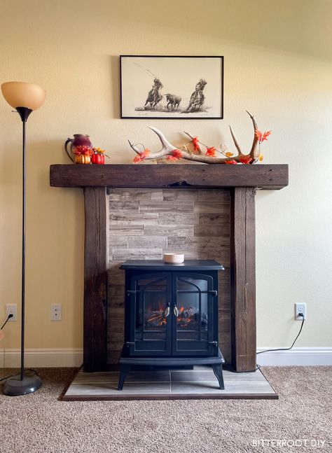 Warm up your living room with a DIY fireplace with an electric stove! The perfect budget friendly solution for that blank wall in your house. #diyfireplace #diyprojects #livingroom #fireplaceideas #livingroomdesign Diy Gas Fireplace Mantle, Electric Fireplace Stove Ideas, Mantle Over Wood Stove, Faux Fireplace With Electric Stove, Electric Stove Fireplace Flat Wall, Mock Fireplace Ideas, No Fireplace Living Room, Small Electric Fireplace Ideas, Rustic Electric Fireplace Ideas