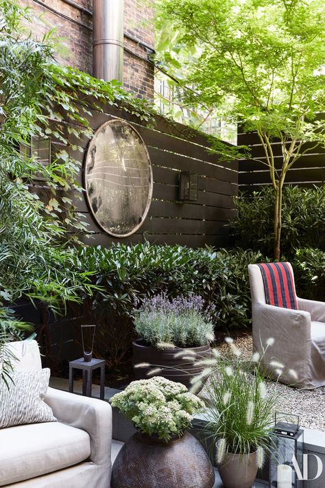 In the garden, designed by Harrison Green, custom armchairs by August Studios wear a Holly Hunt acrylic. Vintage highway mirror on wall. Nyc Townhouse, Small Patio Garden, Minimalist Garden, Garden Mirrors, East Village, Small Garden Design, Little Garden, Courtyard Garden, Small Gardens