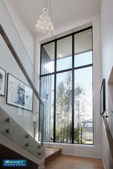 Large fixed windows bring in plenty of light while making a statement in the stairway void. Click to see the full customer story and more photos of this home. Stairs With Glass Window, Modern Glass House Design Big Windows Exterior, Windows On Staircase Wall, Stair Case Windows Design, Fixed Windows In Living Room, Staircase Window Design Exterior, Hall Windows Ideas, Staircase Window Design Modern, Stairs Window Design