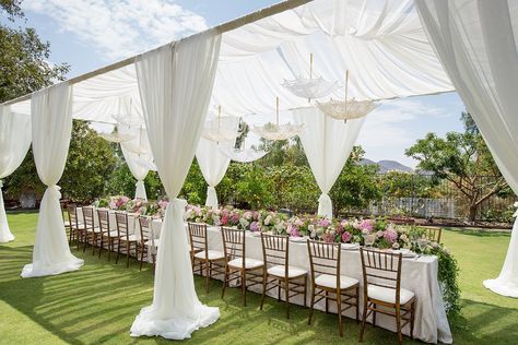 white-drapes-surrounding-long-bridal-shower-table-with-flower-table-runner-and-parasols-overhead Bridal Shower Photography, Backyard Bridal Showers, Outdoor Bridal Showers, Wedding Setup, Bridal Shower Decorations Diy, Bridal Shower Tables, Elegant Bridal Shower, Pastel Decor, Wedding Inside