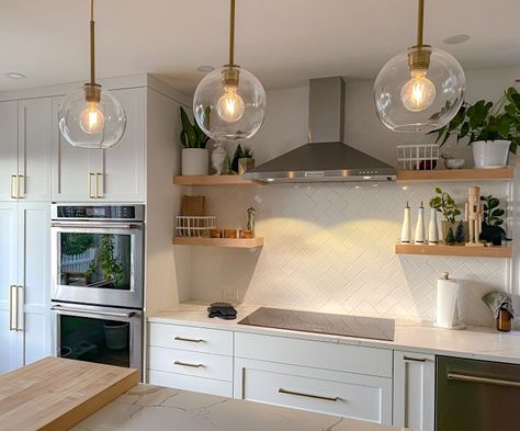 A kitchen with a grey induction cooktop, white cabinets, white tile, and brass pendant lights. Induction Oven Kitchen, Induction Kitchen Design, Kitchen Cooktop Alcove, Induction Stove Kitchens, Induction Cooktop Kitchen Design, Kitchen With Induction Cooktop, Kitchen With Cooktop, Victorian Kitchen Remodel, Induction Cooktop Kitchen