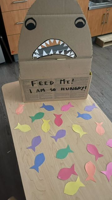 Brooke and Cat on Instagram: "Feed the Shark !🦈 . . . This week the toddler have had a great interest in water animals. So I thought this easy fun activity would be the right fit. All handmade. . . All you need is a cardboard box, some construction paper and your creativity. . . . Don’t forget to save and follow for more great ideas. . . . #popular #instagram #trending #follow #love #viral #like #instagood #explorepage #photography #explore #likeforlikes #followforfollowback #music #fashio Feed The Shark Activity, Water Animal Activities For Preschool, Aquatic Animals Preschool Activities, Baby Shark Activities For Toddlers, Sea Animals Activities For Toddlers, Shark In The Park Activities Eyfs, Shark Activities For Preschool, Sea Animals Preschool, Feed The Shark