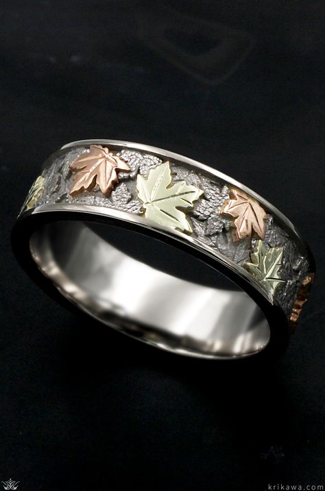 The maple leaf is a beautiful symbol of unity, tolerance, and peace. This band features hand-carved maple leaves in three metal colors wrapping the ring in an eternity style design. This band is perfect for nature lovers with the organic textures among the leaves. Choose your three favorite metals to represent the layered leaves that wrap this band. Men’s Wedding Rings Floral, Nature Inspired Wedding Ring Men, Mens Wedding Bands With Trees, Leaf Engraved Wedding Band, Oak Leaf Wedding Band, Gold Liner, Leaf Wedding Rings, Mens Ring Designs, Leaf Wedding Band