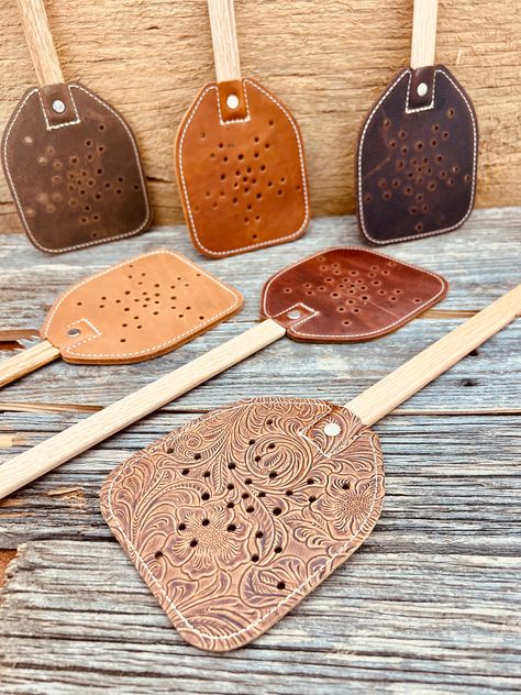 Hand crafted from finished leather and premium wood, this is more than a tool to rid your home of pests. This is the first flyswatter that can hang prominently alongside your living room or kitchen showpieces. Make a place on the wall next to grandpa's fishing pole or junior's shotgun. Be ready for guests, family, friends and neighbors to comment with admiration while glancing to and fro hoping to hunt down one of nature's most annoying pests, then flying into action grabbing this swatter and ending the existence of that buzzing nuisance with wings. It comes in a variety of colors to match your decor perfectly. Makes a great gift for anyone who hates flies. Leather Sheets Craft Ideas, Laser Leather Ideas, Leather Scraps Ideas, Diy Leather Engraving, Cowhide Ideas, Leather Projects Ideas, Scrap Leather Projects, Leather Fly Swatter, Diy Leather Gifts