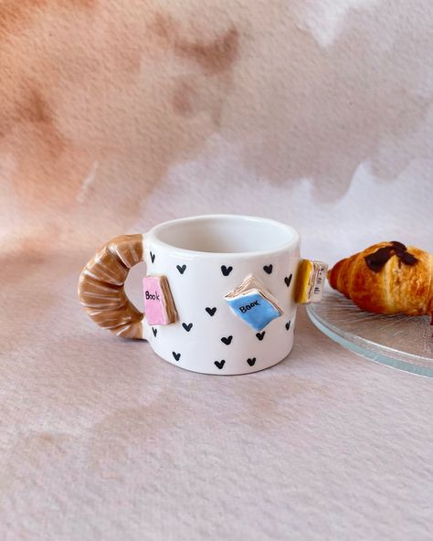 Start your mornings with the perfect blend of coffee and books! 📚☕ Our ceramic mug with book details and a croissant handle is a must-have for book lovers. #etsy #booklover #bookish #ceramicgift #BookLovers #Handmade #CoffeeTime #UniqueDesign Book Pottery, Cute Croissant, Book Ceramic, Croissant Coffee, Creative Mug, Library Bookshelf, Book Mug, Ceramics Pottery Bowls, Ceramic Art Sculpture