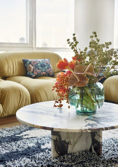 Living room with gold cozy sofa, round marble coffee table, aqua vase with large bouquet of flowers, shag rug Marble Coffee Table Living Room, Round Coffee Table Styling, Large Bouquet Of Flowers, Round Marble Coffee Table, Sofa Round, Cabinet Hack, Coffee Table Flowers, Marble Tables Living Room, Marble Living Room