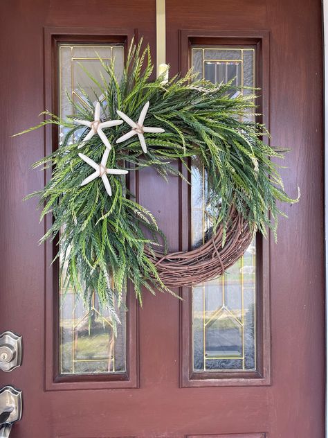 This artificial beach wreath will be perfect for your front door year round. Treat yourself or gift for a birthday, housewarming, or bridal shower. It would also make a great gift for a new beach home or condo owner.  My wreaths are made with careful attention to detail using high quality artificial materials. This design begins with an 18 inch natural grapevine base, however the completed look measures approximately 24 inches in width, 24 inches in length, and is approximately 6 inches in depth. The three retin starfish pair well with the flowy artificial greenery and create a unique coastal aesthetic. The starfish have been painted a neutral bleached sand shade.  I would recommend hanging under a covered porch or indoors for longevity. You can find specialty wreaths for all occasions by Ocean Winter Aesthetic, Indoor Wreaths Year Round, Beach Front Door Decor, Coastal Fall Wreaths For Front Door, Coastal Door Wreath, Beach Christmas Wreath, Neutral Beach Decor, Summer Door Wreaths Diy, Summer Grapevine Wreath Ideas