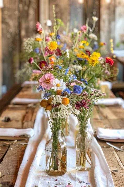 Flower Garden Wedding Decor, Fruit And Flower Table Decor, Wildflower Long Table Wedding, Colorful Wild Flower Wedding, Wild Flower Backyard Wedding, Summer Garden Table Setting, Wedding Table Decorations Wild Flowers, Boho Wildflower Wedding Table Decor, Wine Bottle Flower Arrangements Wedding