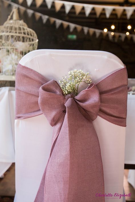 Dusky pink fabric bow at a rustic springtime wedding Bows For Wedding Decorations, Bows On Chairs Wedding, Dusky Pink Wedding Theme, Chair Bows Wedding, Spring Wedding Theme, Hessian Wedding, Bow Chair, Wedding Ceremony Decorations Indoor, Wedding In Spring