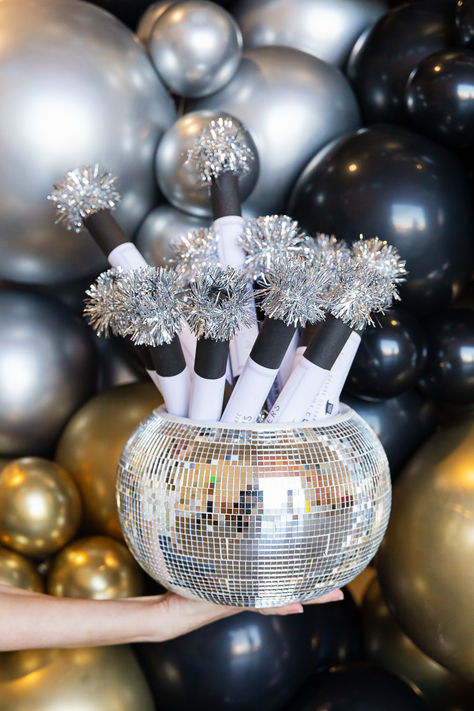 New Year's Eve party favors are for any NYE celebration! We suggest gathering some sparklettes, party horns, and crackers to display on your bar cart or party table. Arrange them in a large disco bowl to create a dazzling DIY centerpiece! New Years Eve Pinata, Disco Ball New Years Eve Party, New Year’s Eve Party Favors, Nye House Party Aesthetic, New Years Disco Party Ideas, New Years Eve Theme Party Ideas, Disco New Years Eve Party, New Years Kids Party, Silver New Years Eve Party