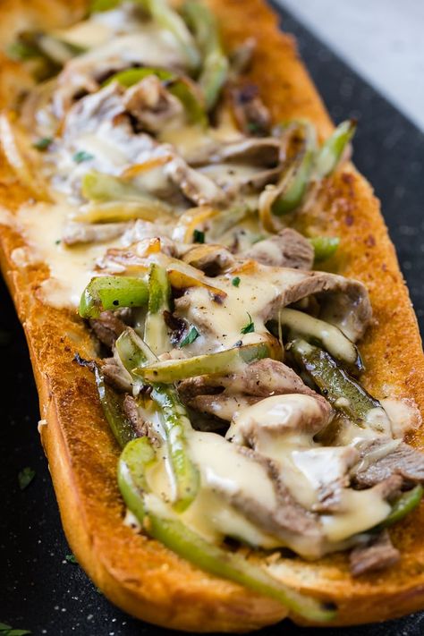 a french bread sliced open and filled with peppers, onions, steak and cheese sauce to make an easy philly cheesesteak recipe! Philly Cheese Steak With Cheese Sauce, Cheese Sauce Philly Cheesesteak, French Bread Philly Cheese Steak, Philly Cheese Steak Rice Bowls, Cheese Sauce For Philly Cheese Steak, Philly Cheesesteak Sauce, Cheesesteak Sauce, Philly Cheese Steak Sauce, Cheesesteak Bread