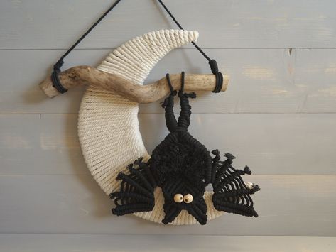 "Spooky macrame bat wall/door hanger.  If you want to stylishly enhance your home or surroundings for Halloween, or just enjoy seasonal decorations, then this macrame bat is the perfect choice for you. The bat hangs off of a branch of tree with the moon in the back.  Handmade using driftwood, black cotton, white cotton and cardboard. A unique piece of funny Halloween decoration. The driftwood measures approx.  20cm   (7,9\") The bat approx.  16x19cm   (6,2\"x 7,4\") Total diameter  30cm   (11,8\ Halloween Macrame Wall Hanging, Macrame Bat Wall Hanging, Macrame Bats Diy, Fall Macrame Wall Hanging, Macrame Unicorn, Spooky Macrame, Macrame Witch, Bat Macrame Tutorial, Macrame Fall Projects