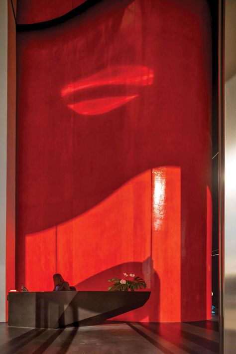 Walls in the lobby are lacquered red, the project’s—and the city’s—signature color. Bamboo Decking, Lacquered Walls, Red Sculpture, Residential Tower, Custom Chandelier, Custom Chair, Community Space, Steel Panels, The Lobby