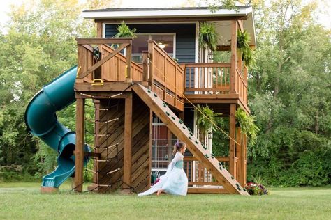 Adam Boyd built his two young daughters a stunning playhouse in their backyard. The playhouse has a rock wall, a slide, swings, a loft, and more. 2 Story Playhouse, Two Story Playhouse, Outside Playhouse, Playhouse Plans, Diy Playhouse, Backyard Playhouse, Build A Playhouse, Diy Playground, Cubby House