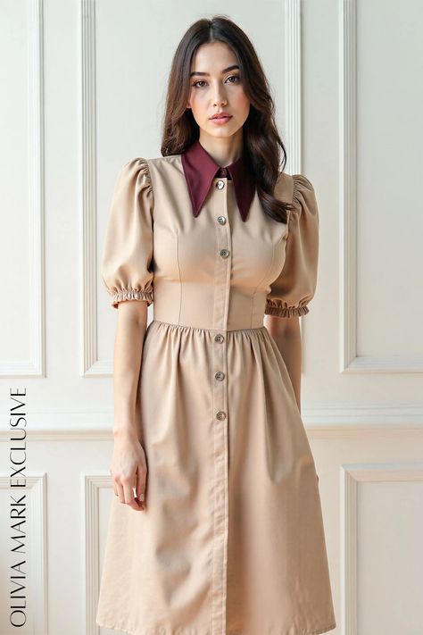 Crafted with a delicate beige canvas, this garment breathes life with its contrasting burgundy collar, a touch that speaks volumes of understated luxury. The puff sleeves, cinched at the wrists with a hint of ruffle, dance with a whisper of vintage charm, while the buttoned front adds a refined touch. A cinched waist accentuates your silhouette before cascading into a full skirt that flatters every step. Olivia Mark's dress is not just attire; it's a storybook character come to life, a piece that whispers tales of past eras while seamlessly intertwining with contemporary grace. Cascade Collar, Understated Luxury, Puffed Sleeves, Cinched Waist, Collar Dress, Full Skirt, Olivia Mark, Puff Sleeves, Elegant Dresses