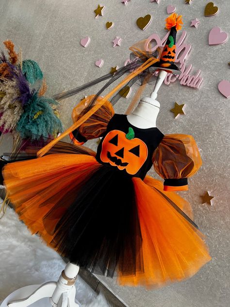 Halloween Dress This Halloween dress, the sweetest option of Halloween, will be very good for your children! This dress, which has a very fluffy skirt, a short-sleeved top, and an orange-black color suitable for the Halloween theme, is designed to make children happy. The hair accessory of the dress is included with the dress. This hair accessory completes the outfit. The hair accessory and dress combination will look great on girls. Toddler Girl Witch Costume, Puffy Birthday Dress, Costume Toddler Girl, Tulle Costume, Tulle Costumes, Flower Girl Dress Baby, Halloween Costume Toddler Girl, Birthday Costume, Halloween Party Dress