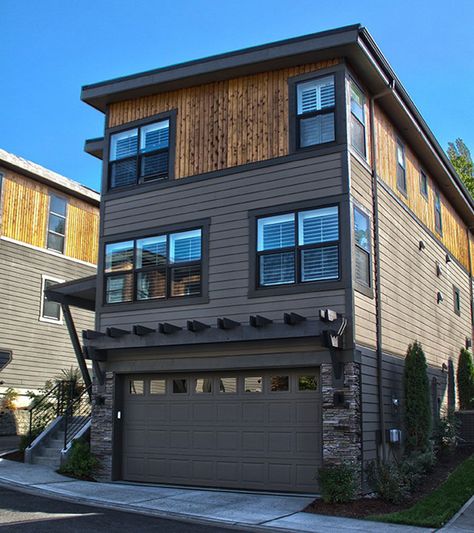 A combination of slanted and flat roofing gives this Northwest house plan a Contemporary feel. Designed for a lot that slopes to the front, the home has living space on three levels. The garage level also includes a fourth bedroom and bathroom plus a big rec room where you can send the kids to play. On the main floor, choose to relax in the formal living and dining area at the front of the home or the informal area in back. The kitchen island is nicely positioned to take in the views of the fami Narrow Lot House, Narrow Lot House Plans, Townhouse Designs, Garage House Plans, Narrow House, Casa Container, Inspire Me Home Decor, Modern House Plan, House Blueprints