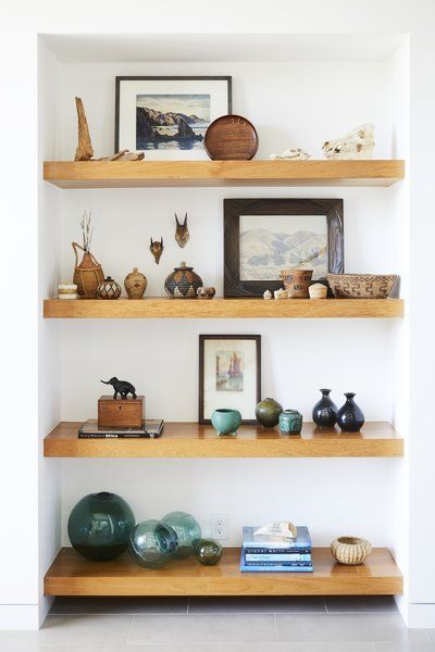 Teak shelves were used in the entryway to display the owners' art collection and souvenirs from abroad. Tagged: Living Room, Shelves, Bookcase, and Storage.  Photo 2 of 12 in This Renovation Will Make You Rethink the Typical Look of a California Beach House Impressive Homes, Teak Shelves, Beach Community, Office Styling, California Beach House, Modern Coastal Home, Indian Living Room, Indian Living Rooms, Blue Backdrop