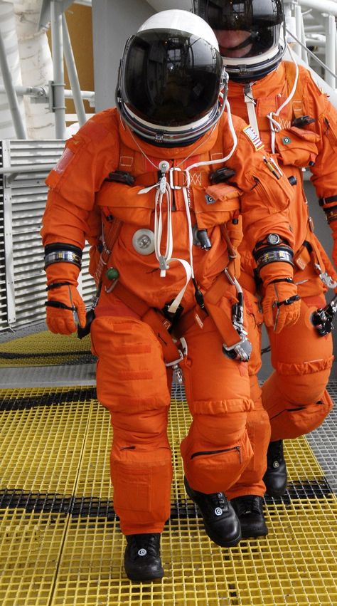 On Launch Pad 39A at NASA's Kennedy Space Center in Florida, members of space shuttle Endeavour's STS-130 crew, dressed in their helmets and launch-and-entry suits, approach the pad's slidewire baskets, part of the emergency exit system at the pad. Pumpkin Suit, Astronaut Suit, Apollo 1, Space Fashion, Nasa Astronauts, Neil Armstrong, Space Race, Space Odyssey, Space Suit