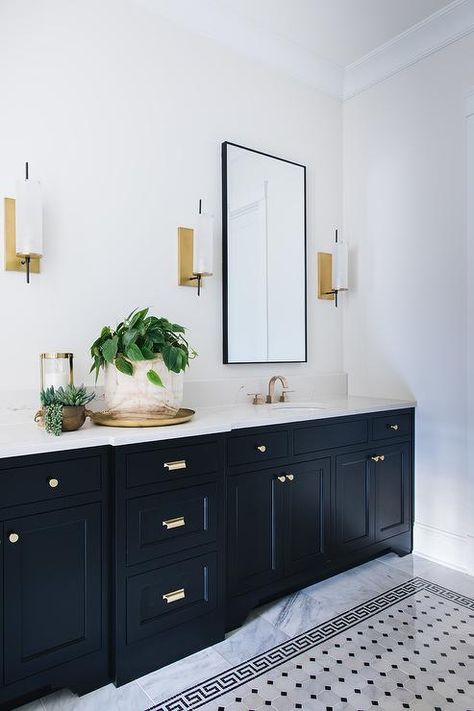 Gray marble floor tiles accented with black greek key border tiles are positioned in front of a black shaker bath vanity adorned with vintage brass pulls and a white quartz countertop finished with brass faucets. Grey Marble Floor, Black Cabinets Bathroom, Black And White Bathroom, Black Vanity Bathroom, White Bathroom Tiles, Bathroom Cabinetry, Townhouse Designs, Marble Tile Floor, Black Vanity