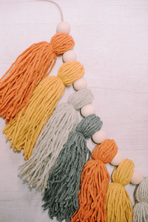 Learn how to make a fall yarn tassel garland using fall colored yarn tassels, wooden beads, and twine to make a garland. Rainbow Tassel Garland, Pom Pom Letters, Yarn Tassel Garland, Make A Garland, Thanksgiving Garland, Diy Tassel Garland, Yarn Tassel, Tassel Crafts, Diy Yarn