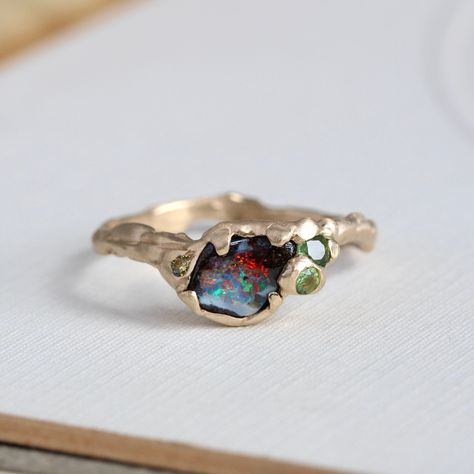 Our handmade 14k yellow gold boulder-opal ring celebrates the natural beauty of this fascinating gemstone, a unique specimen with vibrant flashes of firey orange, red, lime and electric turquoise blue. Accents of green sapphire, tourmaline, and champagne diamonds play to the sparks of bright color, with a gracefully undulating branch band and hand-hammered texture to emphasize the opal's slightly rustic nature. Shown in the last photo stacked with our custom made Willow band, which is sold separ Tourmaline And Opal Ring, Handmade Wedding Ring, Organic Minimalism, Antique Opal Ring, Gemstone Rings Unique, Raw Opal Ring, Gemstone Stacking Ring, Boulder Opal Ring, Handmade Wedding Rings