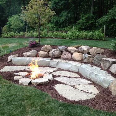 Backyard Fire Pit Ideas | Hunker Fire Pit With Rocks, Outdoor Fire Pit Area, Sunken Fire Pits, Backyard Fire Pit, Fire Pit Ideas, Sloped Yard, Fire Pit Landscaping, Sloped Backyard, Stone Fire Pit