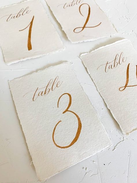 Reception Aesthetic, Gold Wedding Table Numbers, Elegant Table Numbers, Wedding Invitation Details Card, Calligraphy Table Numbers, Vintage Italian Wedding, Letters Calligraphy, Gold Table Numbers Wedding, Handwritten Wedding