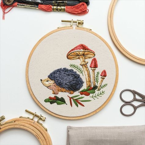 Hand embroidery pattern featuring a woodland scene with red mushrooms, leaves and greenery, along with a cute hedgehog designed to create a fluffy texture. Fall Hedgehog, Hedgehog Embroidery, Embroidery Pattern Design, Hedgehog Pattern, Red Mushrooms, Long And Short Stitch, Woodland Scene, Fall Patterns, Cute Hedgehog