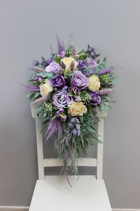 High-quality artificial flower bouquet meticulously crafted by me. Radiating in shades of enchanting violet, this arrangement features stunning orchids and delicate eucalyptus leaves. Each bloom is intricately designed to capture the beauty of real flowers, ensuring a long-lasting and elegant display. Perfect for adding a touch of sophistication to any space, this handmade bouquet is a timeless and maintenance-free floral arrangement that will infuse a lasting vibrancy into your surroundings. ○ Color: purple, ivory, lavender, greenery ○ Personalization: I can make changes to your wishes ○ Processing time: 1 - 2 weeks ○ Shipping time: 14 - 21 business days NOTE ○ I ship with REGISTERED mail and you will get a tracking number. ○ All items will be carefully packed in special package materials Purple Wedding Flower Arrangements, Sage Wedding Bouquet, Josie Wedding, Wedding Flower Arrangements Purple, Altar Flowers Wedding, Cream Wedding Bouquet, Elopement Celebration, Ivory Bouquet, Eucalyptus Wedding Bouquet