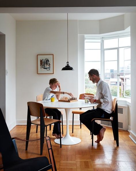 In the dining area, Anatole and Nicholas sit on vintage Prouvé Standard chairs at a Tulip table by Eero Saarinen for Knoll. The enamel pendant is by Labor and Wait. Saarinen Dining Table, Saarinen Table, Marble Tables Design, Tulip Dining Table, Brooklyn Apartment, Tulip Table, Brooklyn Heights, Eero Saarinen, Two Bedroom Apartments