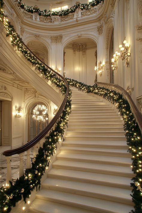 Grand staircase adorned with a festive garland of lights and greenery, complemented by elegant white marble walls in a luxurious mansion. Christmas Wonderland Indoor, Christmas Spiral Staircase, Christmas Staircase Ideas, Elegant Christmas Aesthetic, Luxury Christmas Decor Interior Design, Trending Christmas Decor 2024, Luxury Christmas Aesthetic, Cozy Christmas Bedroom Aesthetic, Christmas Garland Staircase