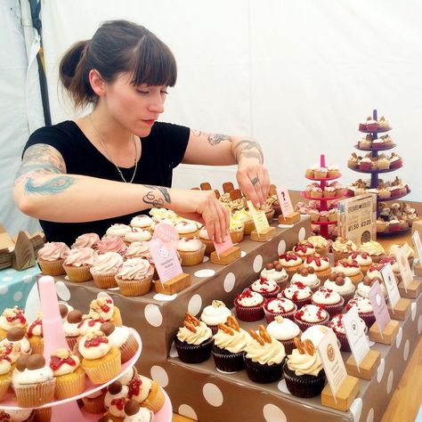 Dubbed London’s “badass baker,” today's #WCW goes out to @jemmajemma. This confectionary wizard has been making the Internet a sweeter place thanks to her @cupcakejemma channel on Jamie Oliver's 1.8 million-strong YouTube network Food Tube. Besides churning out cake-decorating tutorials and recipe walkthroughs, this pastry chef feeds hungry customers with wild flavors at her So-Ho bakery Crumbs and Doilies. #Cupcakes #Baking #CupcakeJemma Bake Sale Display Table Cupcake Stands, Cupcake Sale Display, Bake Stall Ideas, Bake Sale Table Ideas, Cupcake Sale Ideas, Cupcake Stall Display Ideas, Cupcake Market Stall, Dessert Stall Ideas, Cake Booth Display Ideas