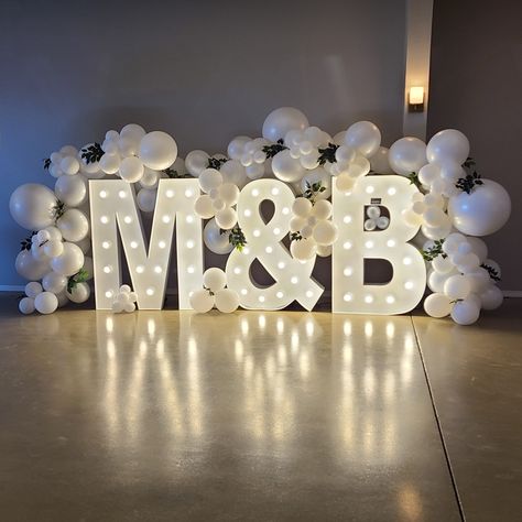 Add a personalized touch to your wedding that really makes a statement with marquee letters! Wrap with balloons to make it a showstopper! So fun for pictures Engagement Marquee Letters, Last Name Balloons Wedding, Engagement Initial Letters Decoration, Engagement Party Marquee, Big Letters Decoration Wedding Ideas, Big Letters For Wedding, Marquee Letters At Wedding, Balloon Decor For Wedding Receptions, Balloon Decorations With Backdrop