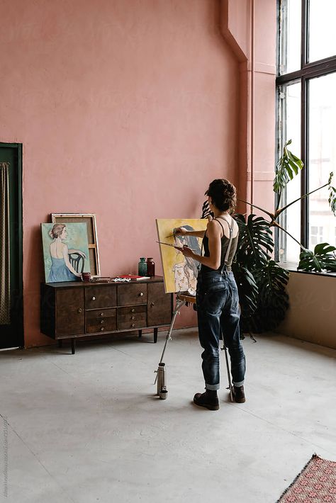 Back view of woman in casual outfit standing near portable easel and drawing portrait while standing in spacious artist workshop Portable Easel, Artist Workshop, Drawing Portrait, Person Standing, Back View