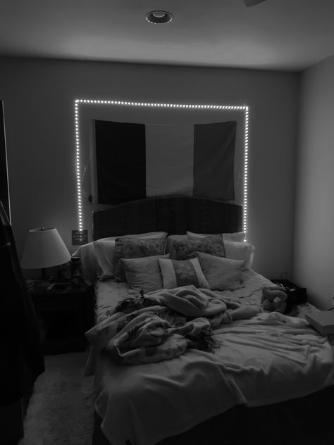 a messily made bed framed by LED lights Grey Room With Led Lights, Black Bedroom With Led Lights, Grey Led Lights Aesthetic, Led Lights Behind Bed, Bed Astethic Dark, Led Lights On Bed Frame Aesthetic, Black Bed Frame Gray Sheets, Comfy Black Beds, Mens Bedroom Led Light