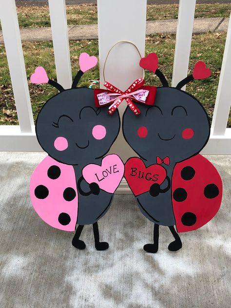 "These adorable love bugs are super cute for your door!! Perfect Valentine's Day decor. Can be customized!! Measures approximately 15\" tall X 16\" wide 1/4\" Plywood Acrylic paints Sealed to prevent fading All my signs are hand drawn, cut and painted by me in my basement. You are getting a 100% handmade item. No two will be exactly alike. As with any wood product, there could be variations in color or texture, this just adds to the unique, whimsical nature of the product. All signs are shipped Bug Decor, Valentine Door Hanger, Valentines Day Aesthetic, Valentines Diy Kids, Halloween Party Activities, Ladybug Decorations, Valentines Door Hanger, Wood Yard Art, Ladybug Crafts