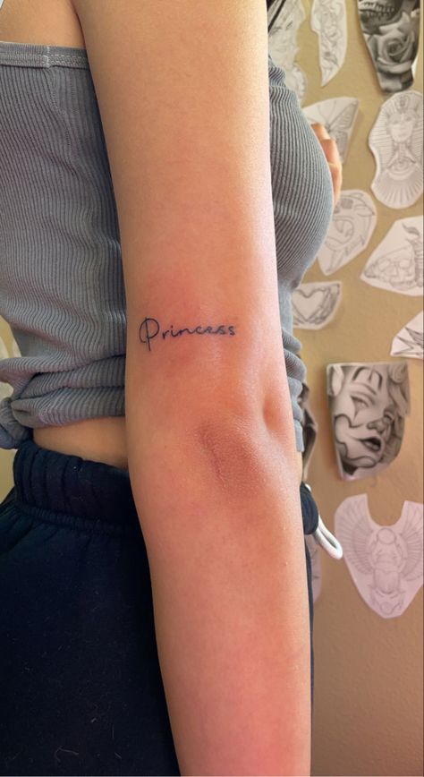 princess tattoo Princess In Arabic Tattoo, Princess Writing Tattoo, Princesa Tattoo Word, Princess Tattoo Ideas Words, Princess Aesthetic Tattoo, Barbie Tatoos Ideas, Princess Tattoos For Women, Princess Word Tattoo, Princess Tattoo Writing