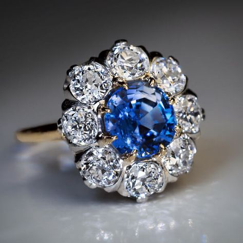 Antique Sapphire and Diamond Engagement Ring, Circa 1910. An antique 18K gold and platinum engagement ring is centered with a 2.24 ct natural blue sapphire surrounded by sparkling bright white old European cut diamonds. Total diamond weight is 2.40 ct. The diamonds are set in platinum over gold. Gold Color Ring, Bijoux Art Nouveau, Diamond Cluster Engagement Ring, Floral Engagement Ring, Antique Wedding Rings, Wedding Party Jewelry, Vintage Sapphire, Colored Engagement Rings, Cluster Engagement Ring